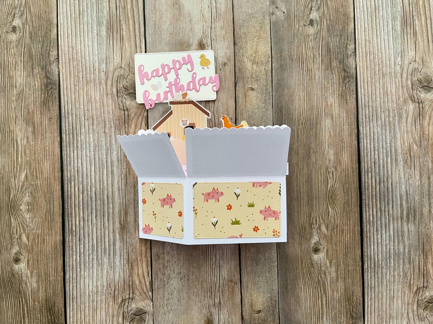 Open card with floral design on a wooden surface
