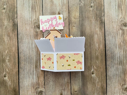 Open card with floral design on a wooden surface