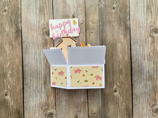 Open card with floral design on a wooden surface