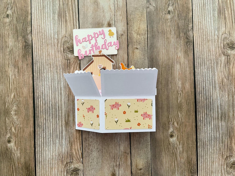 Open card with floral design on a wooden surface
