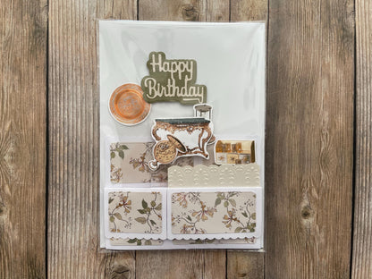 Decorative birthday card with floral patterns and 'Happy Birthday' text on a wooden background