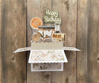 Decorative birthday card with tea cup and teapot design on a wooden background