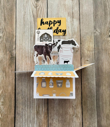Folding card with farm-themed illustrations on a wooden background