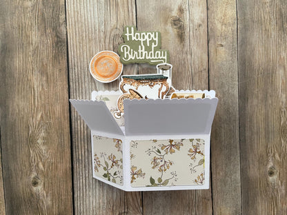 Open card with floral design and 'Happy Birthday' topper on a wooden background