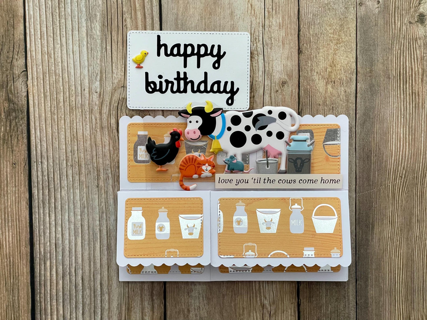 Birthday card with farm animal theme on a wooden surface