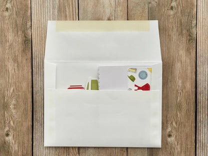White envelope with a colorful card on a wooden surface