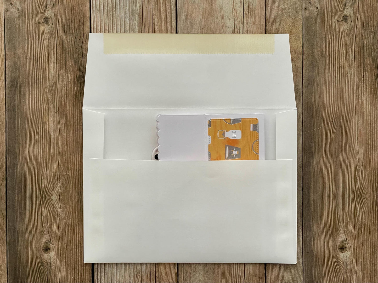 White envelope with a card inside on a wooden surface