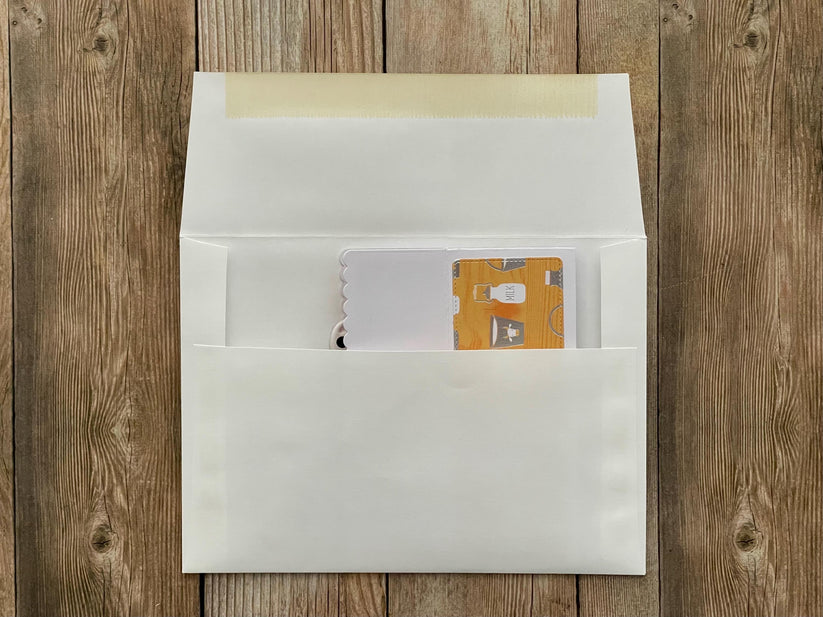 White envelope with a card inside on a wooden surface