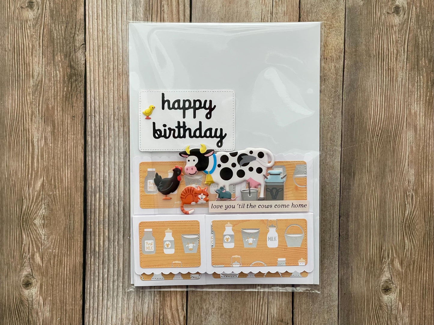Birthday card with farm-themed illustrations on a wooden surface