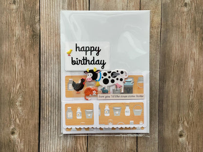 Birthday card with farm-themed illustrations on a wooden surface
