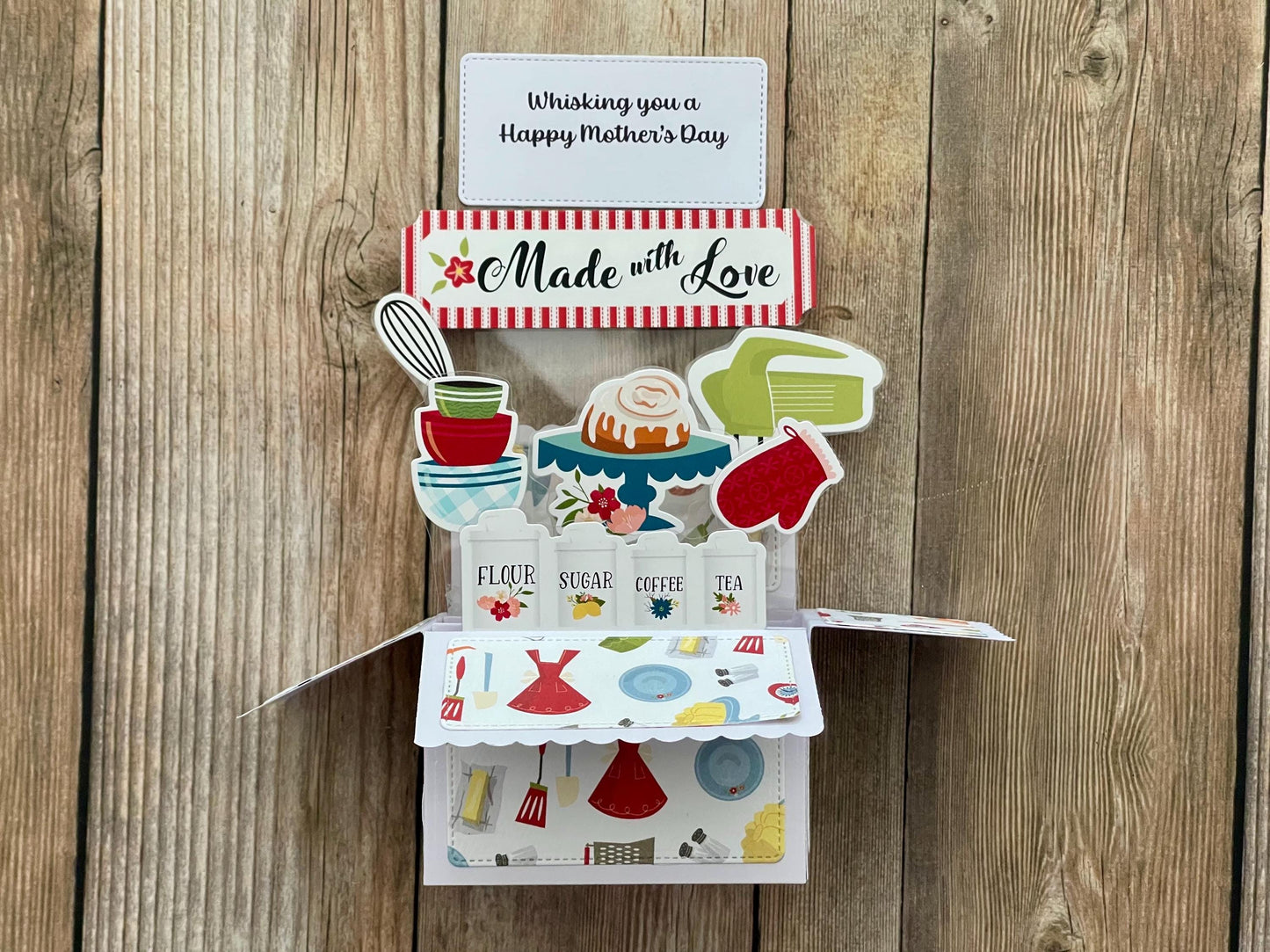 Pop-up  Mother's Day card with a baking theme, 'Made with Love' message and "Whisking you a Happy Mother's Day" on a wooden background