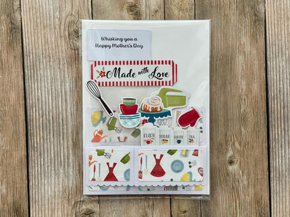 Greeting card with kitchen-themed illustrations and 'Made with Love' text on a wooden surface