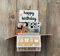 Pop-up birthday card with farm-themed illustrations on a wooden background